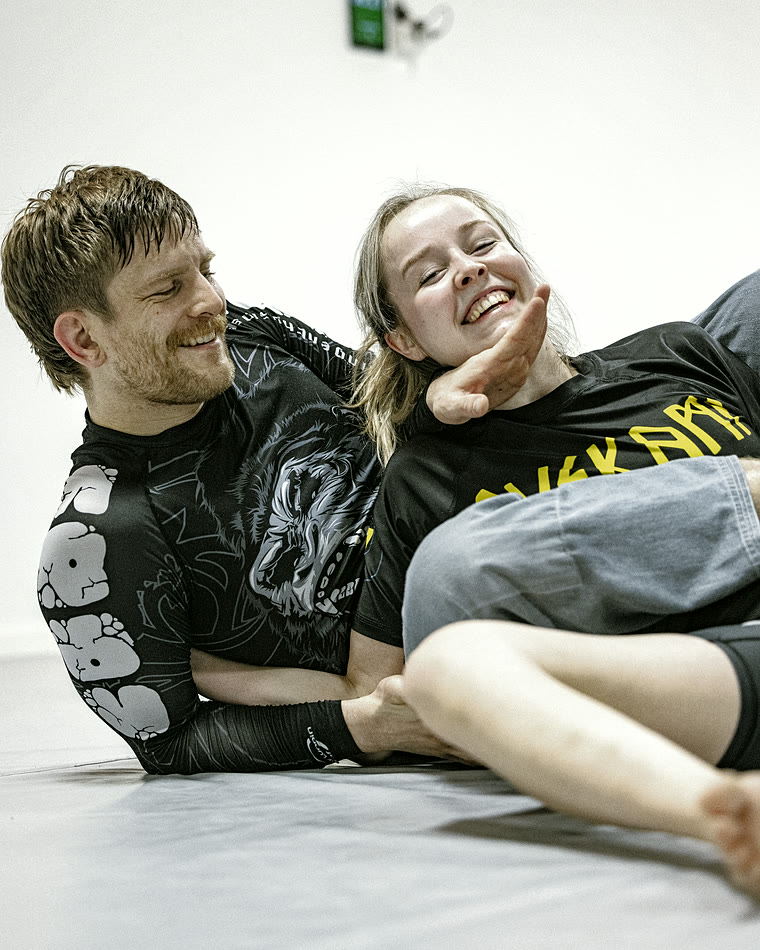 Snorre Martinsøn ler sammen med en treningspartner etter en runde no-gi.