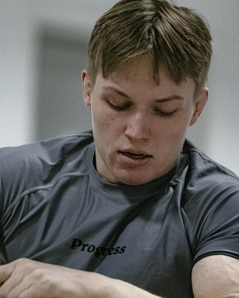 Tomas i grå rashguard, konsentrert om et grep under no-gi.